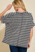 Woman wearing a black and white striped shirt against a beige background