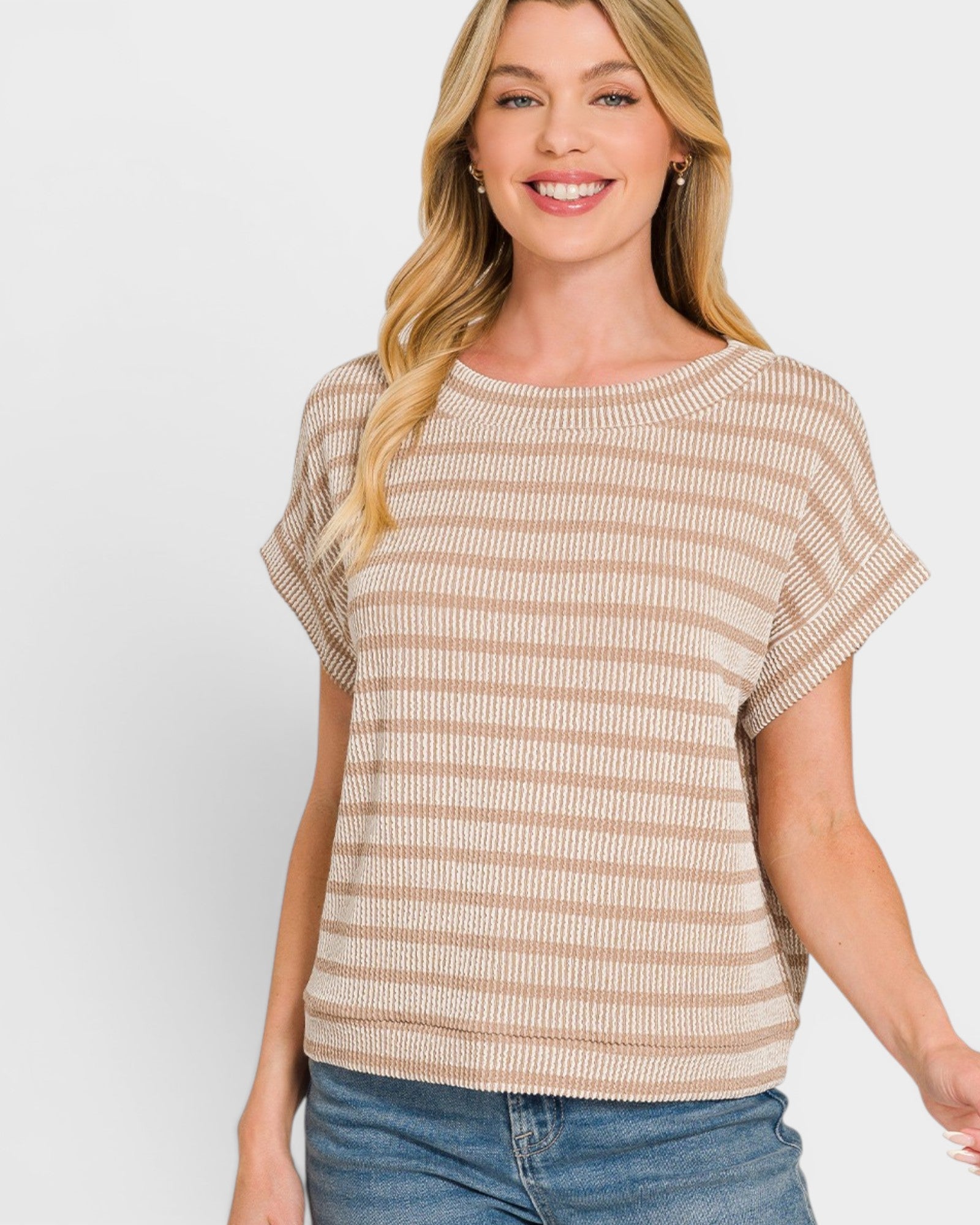 Woman wearing a beige and white striped short-sleeve top on a plain background