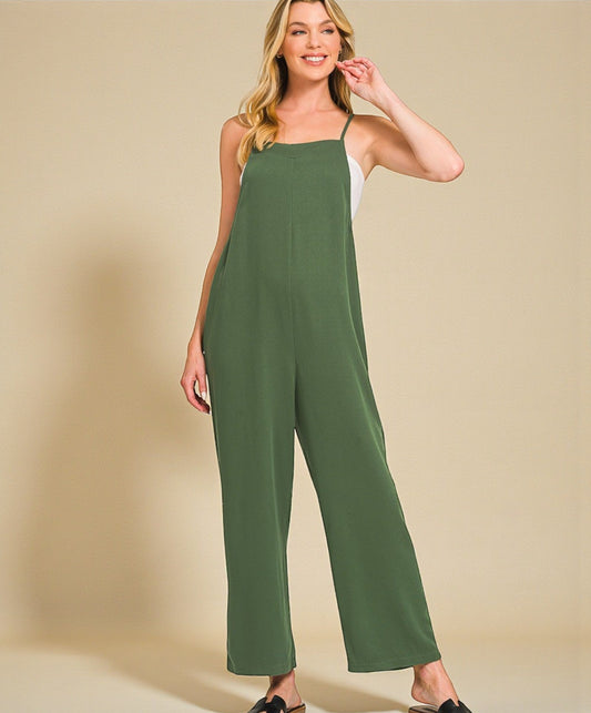 Woman wearing a green jumpsuit on a beige background