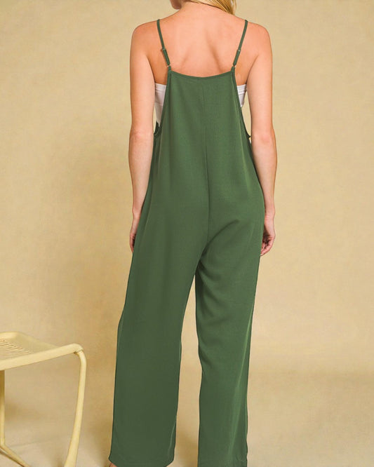 Person wearing a green jumpsuit against a beige background