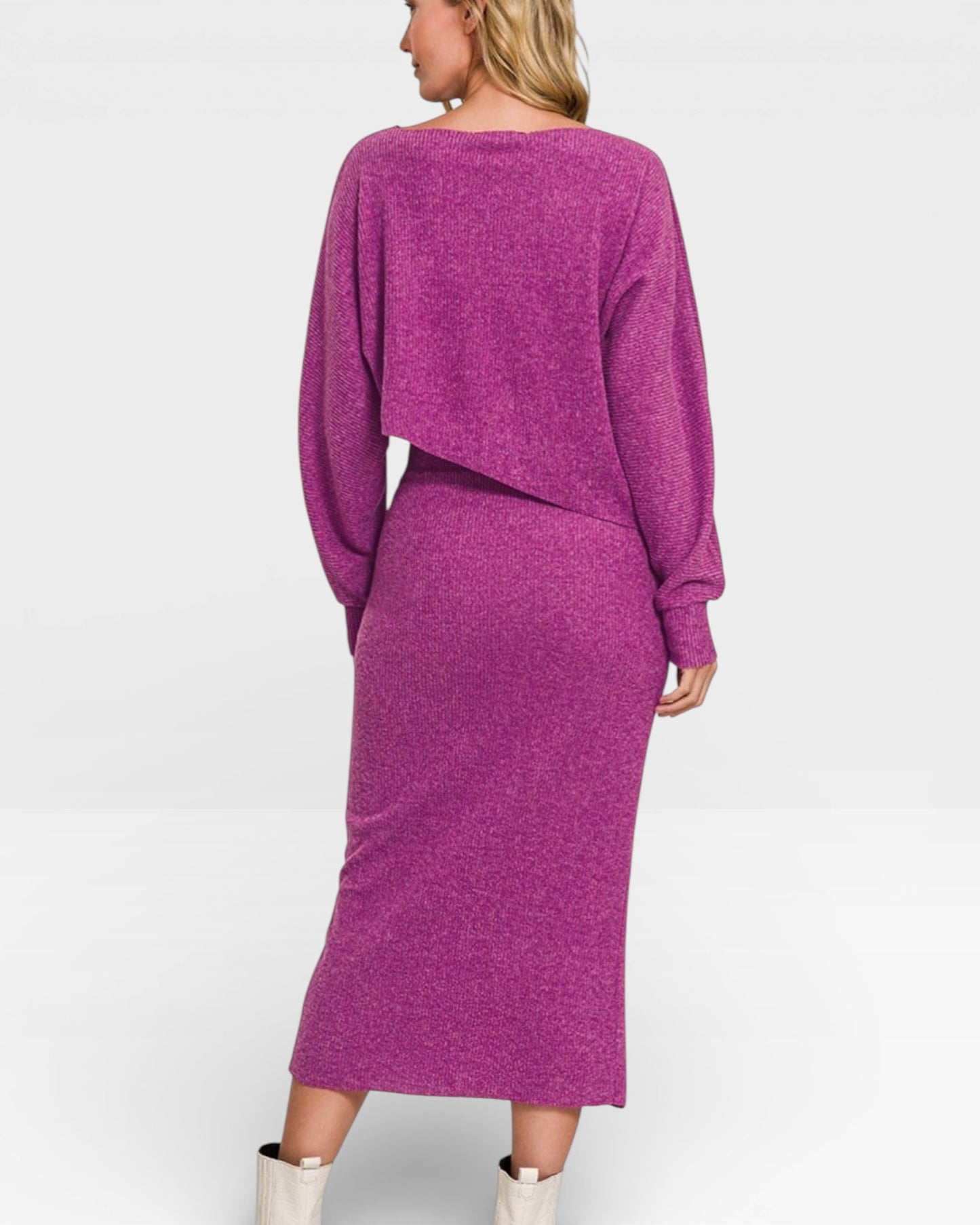 Person wearing a purple knit dress and cardigan on a white background