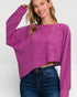 Woman wearing a purple sweater and blue jeans on a white background