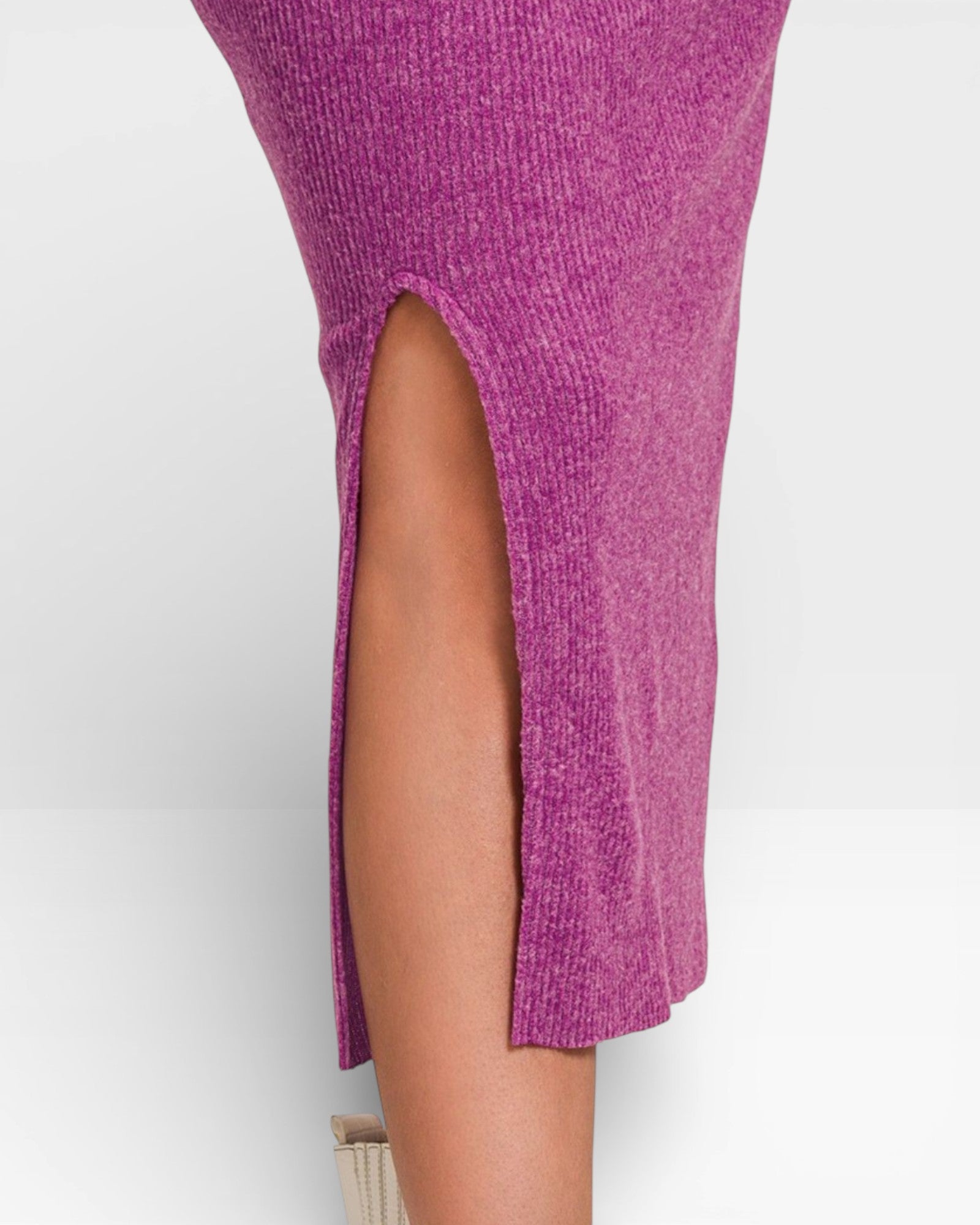 Close-up of a person wearing a purple knit dress with a slit on a white background