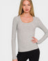 Woman wearing a gray long-sleeve top against a white background