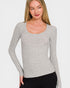 Woman wearing a gray long-sleeve top against a white background
