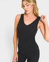 Woman wearing a black bodysuit against a white background