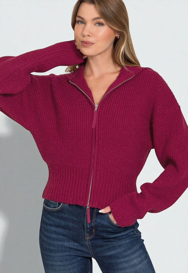 Woman wearing a pink zip-up sweater against a white background