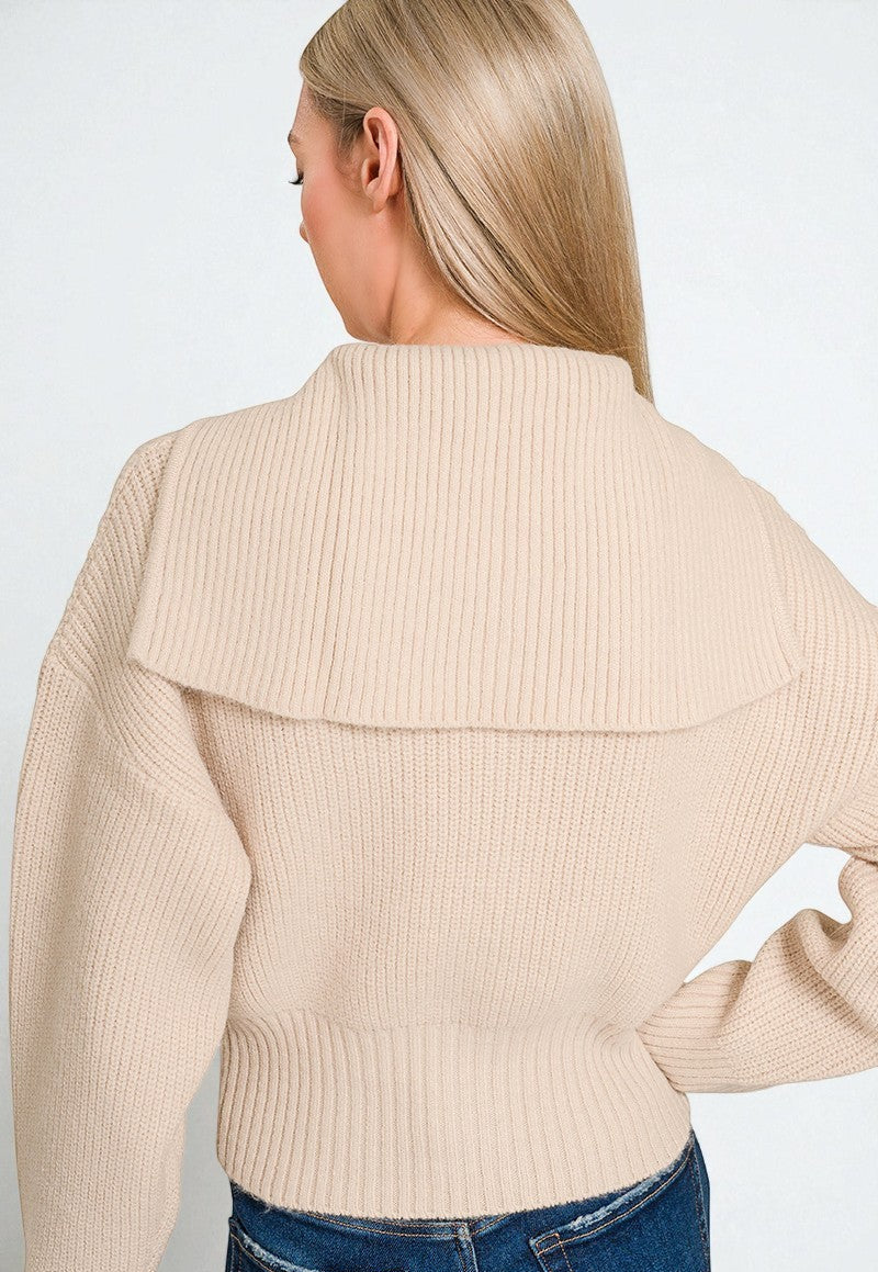 Beige ribbed sweater worn by a person on a white background