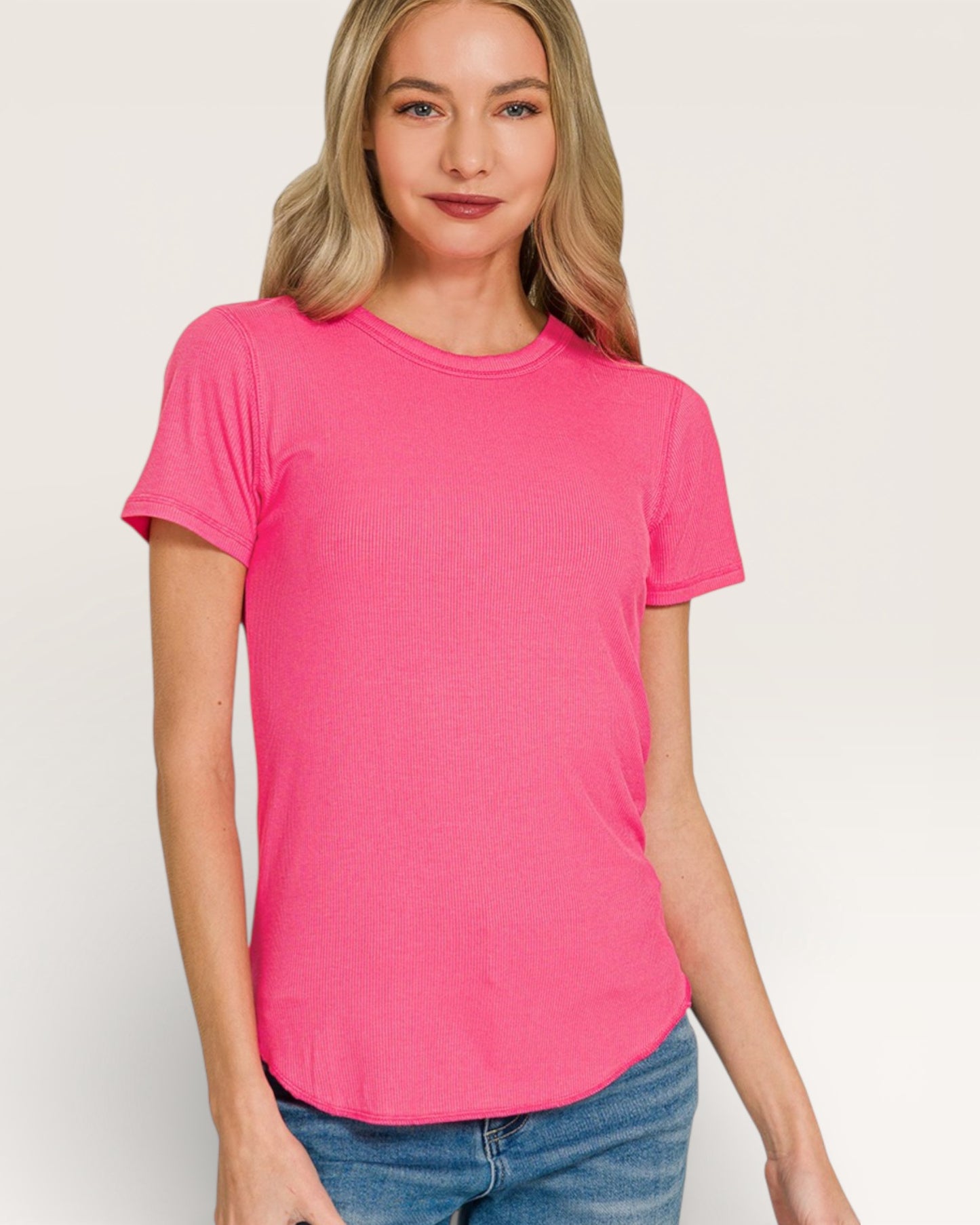 Woman wearing a bright pink t-shirt against a plain background