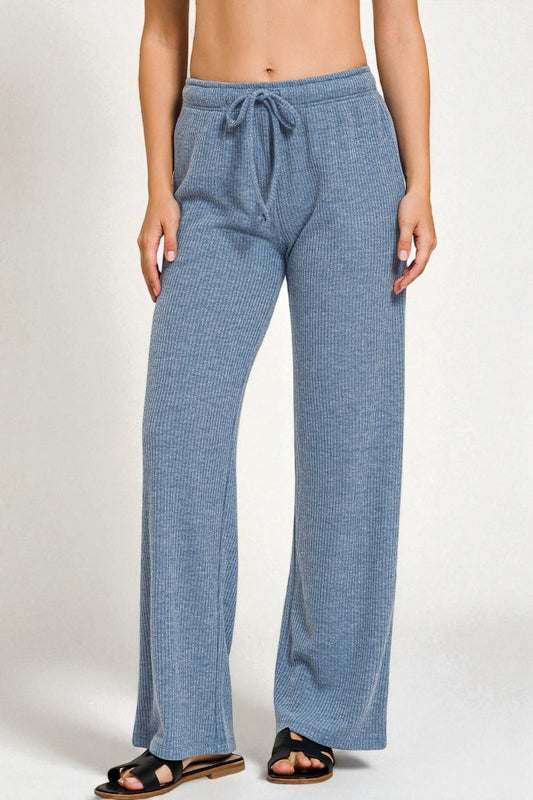 Blue lounge pants worn by a person on a white background