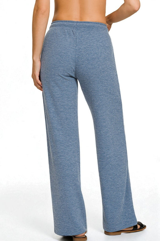 Blue patterned pants worn by a person on a white background