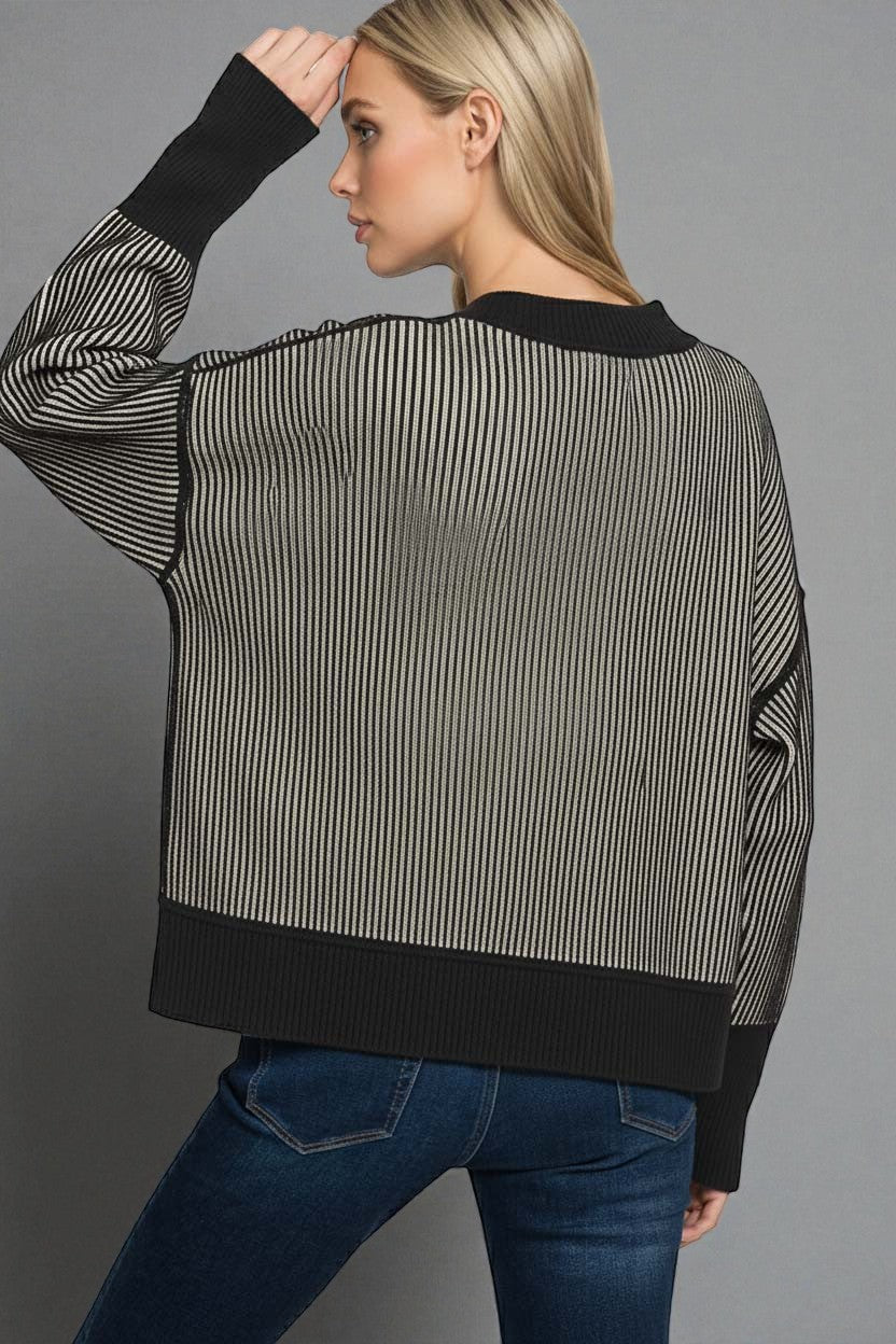 Woman wearing a black and white striped sweater with a gray background