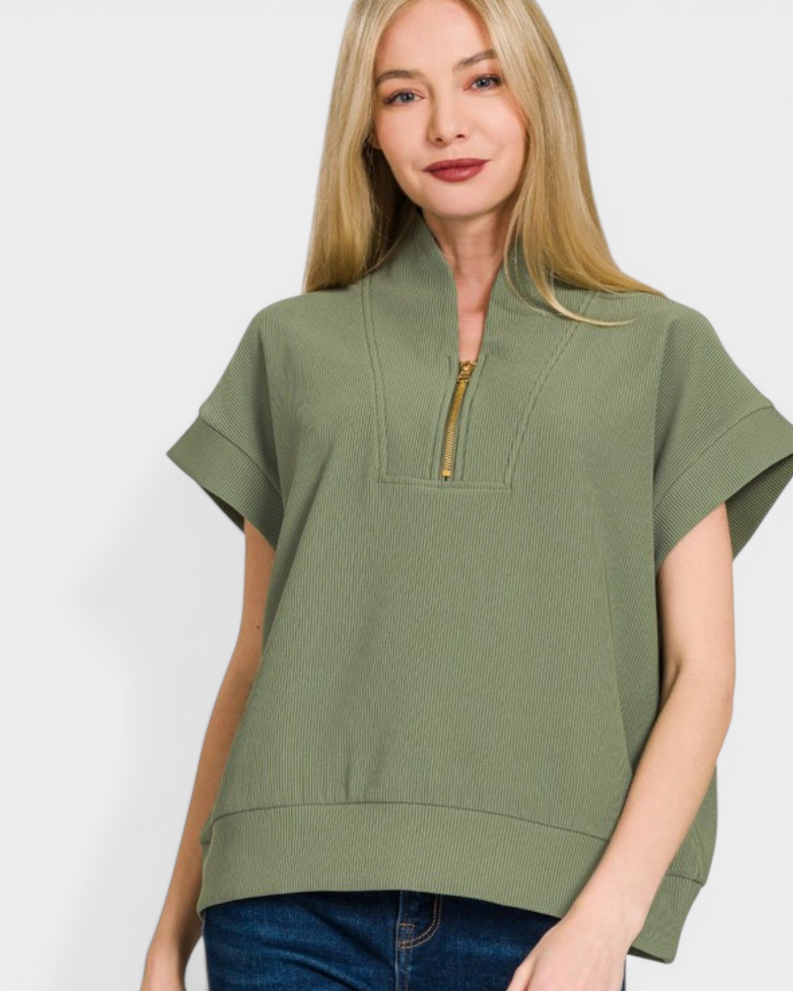 Woman wearing a green short-sleeve top with a zipper on a white background