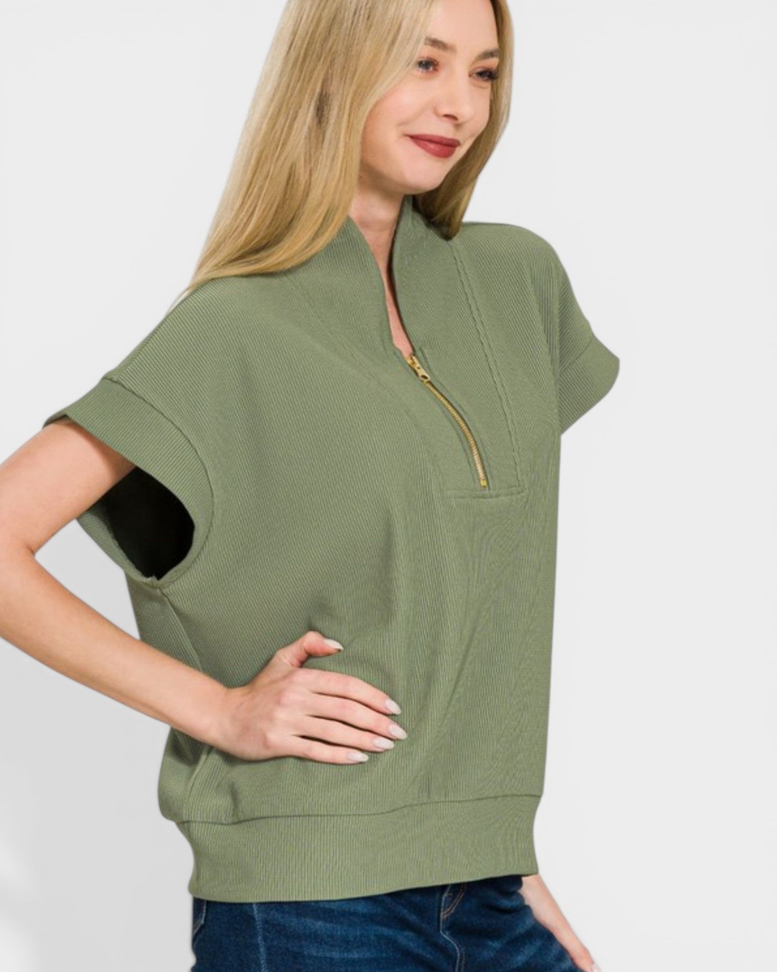 Woman wearing a green zip-up top with a white background