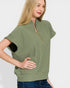 Woman wearing a green zip-up top with a white background