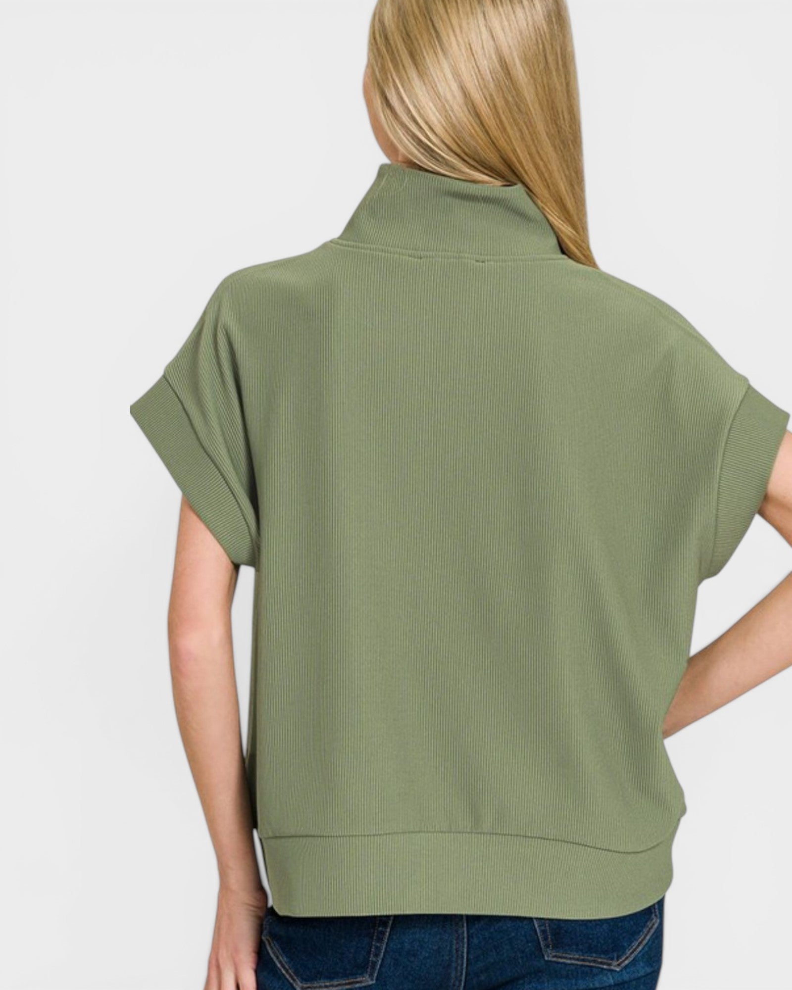 Green sleeveless top worn by a person on a white background