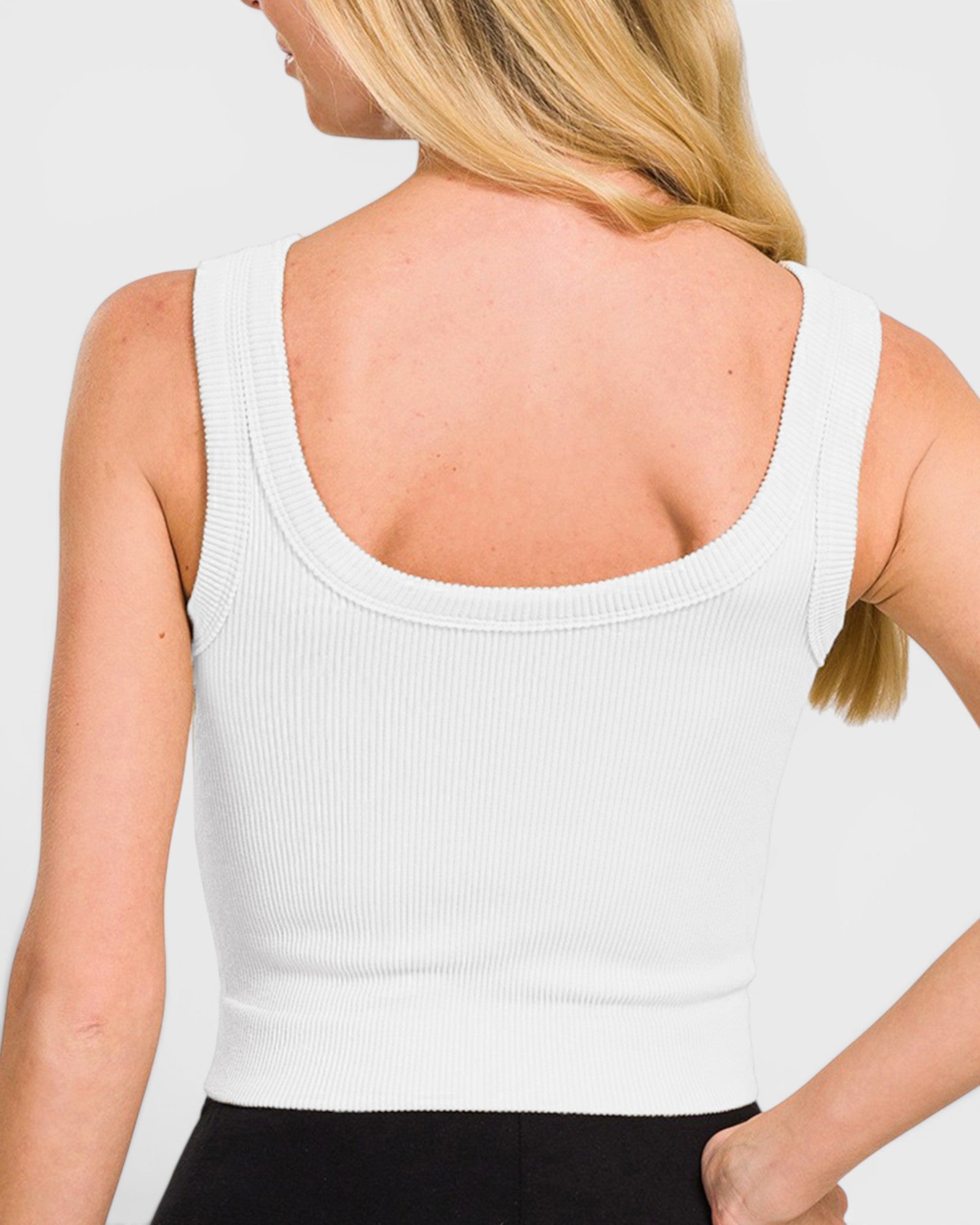 White tank top worn by a person on a plain background