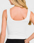 White tank top worn by a person on a plain background