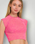 Woman wearing a pink crop top against a plain background