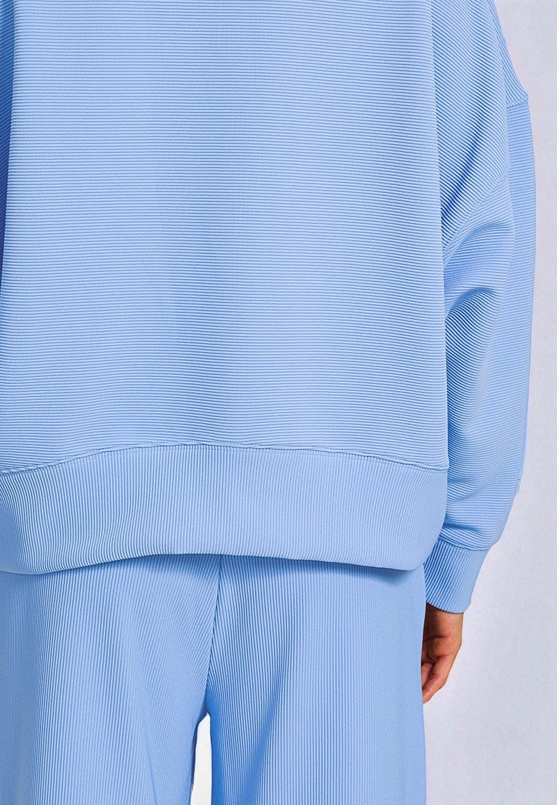 Light blue ribbed sweater and pants set on a white background