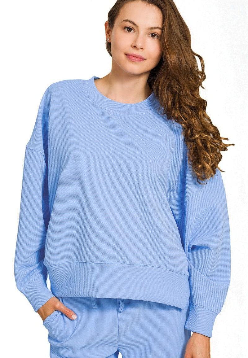 Woman wearing a light blue sweatshirt and pants on a white background