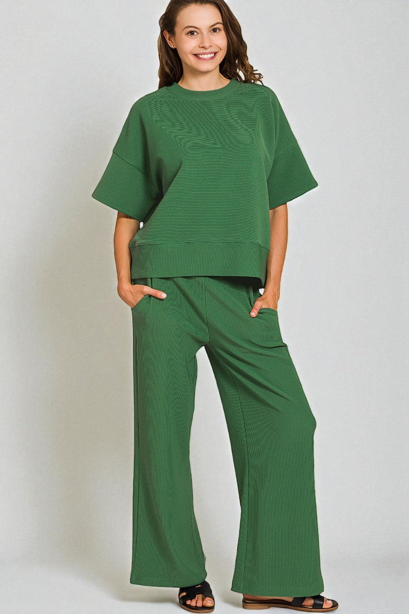 Woman wearing a green outfit on a plain background