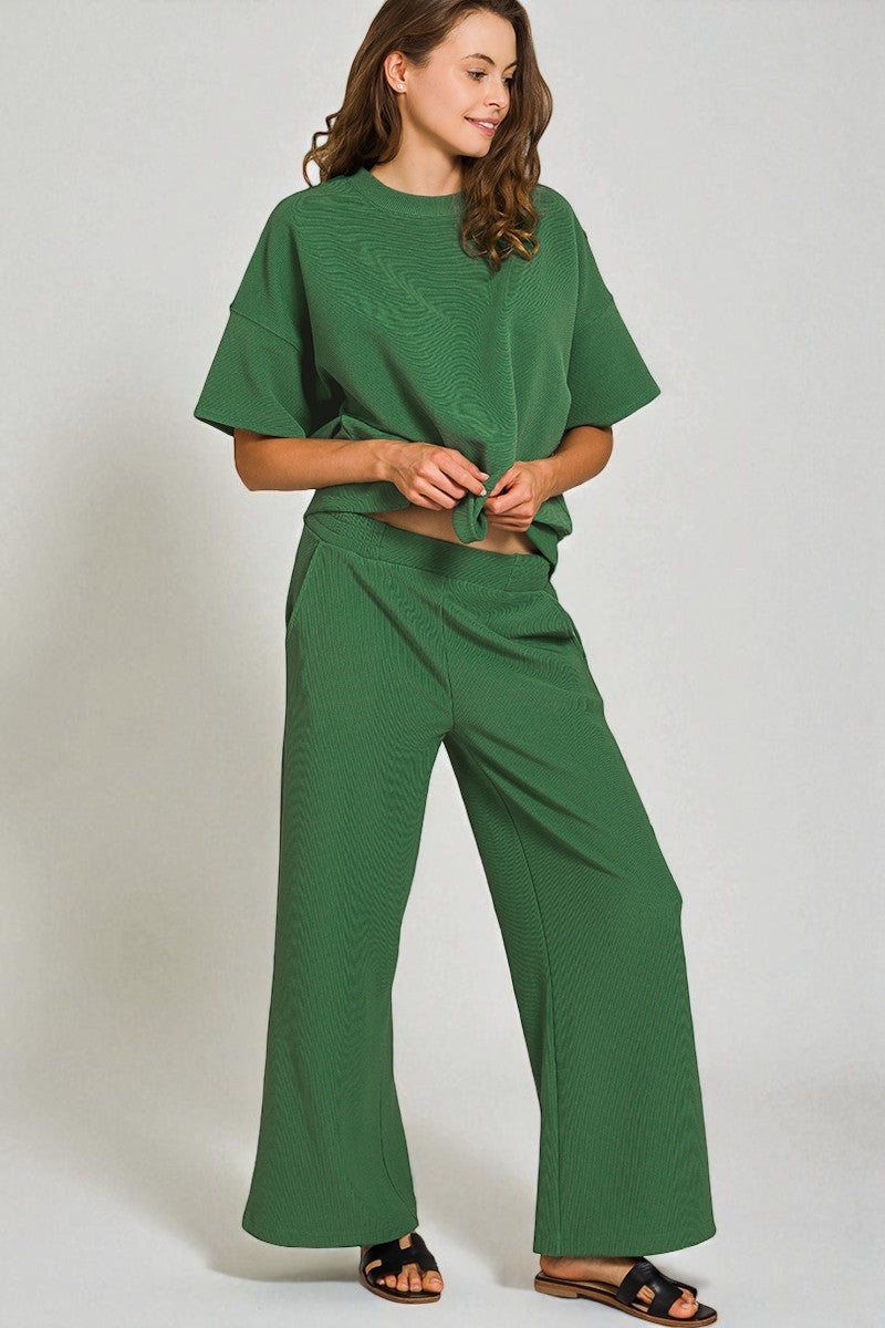 Woman wearing a green outfit against a plain background