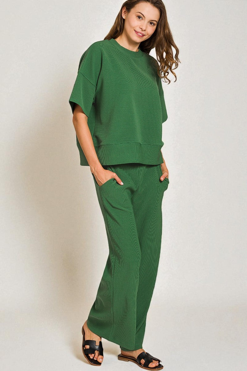 Woman wearing a green outfit against a plain background
