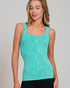 Woman wearing a teal tank top against a plain background