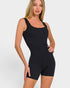 Woman wearing a black bodysuit against a white background
