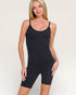 Woman wearing a black bodysuit against a plain background
