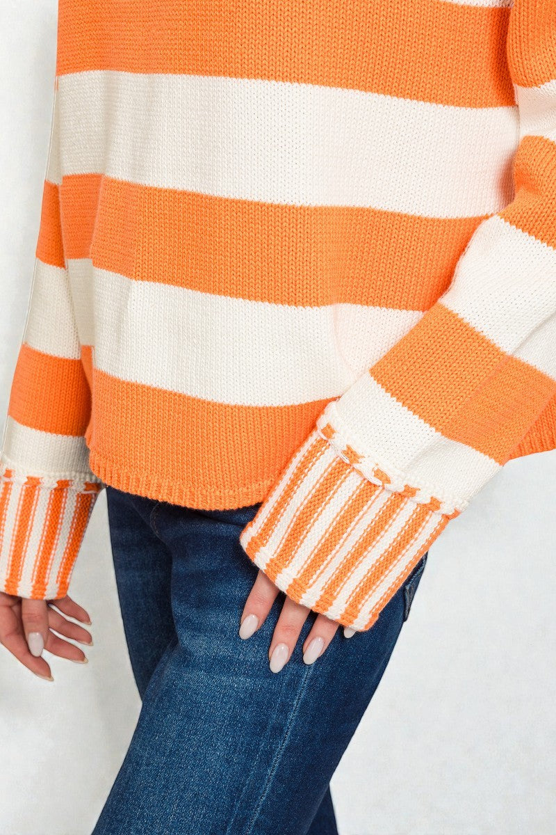 Orange and white striped sweater with blue jeans on a white background
