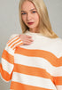 Woman wearing a white and orange striped sweater against a gray background