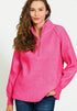 Woman wearing a pink long-sleeve shirt with a quarter-zip on a white background