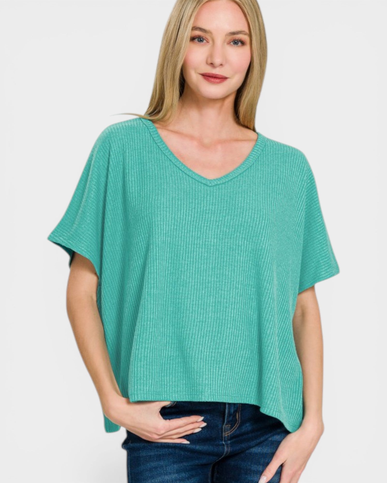 Woman wearing a teal oversized sweater on a white background