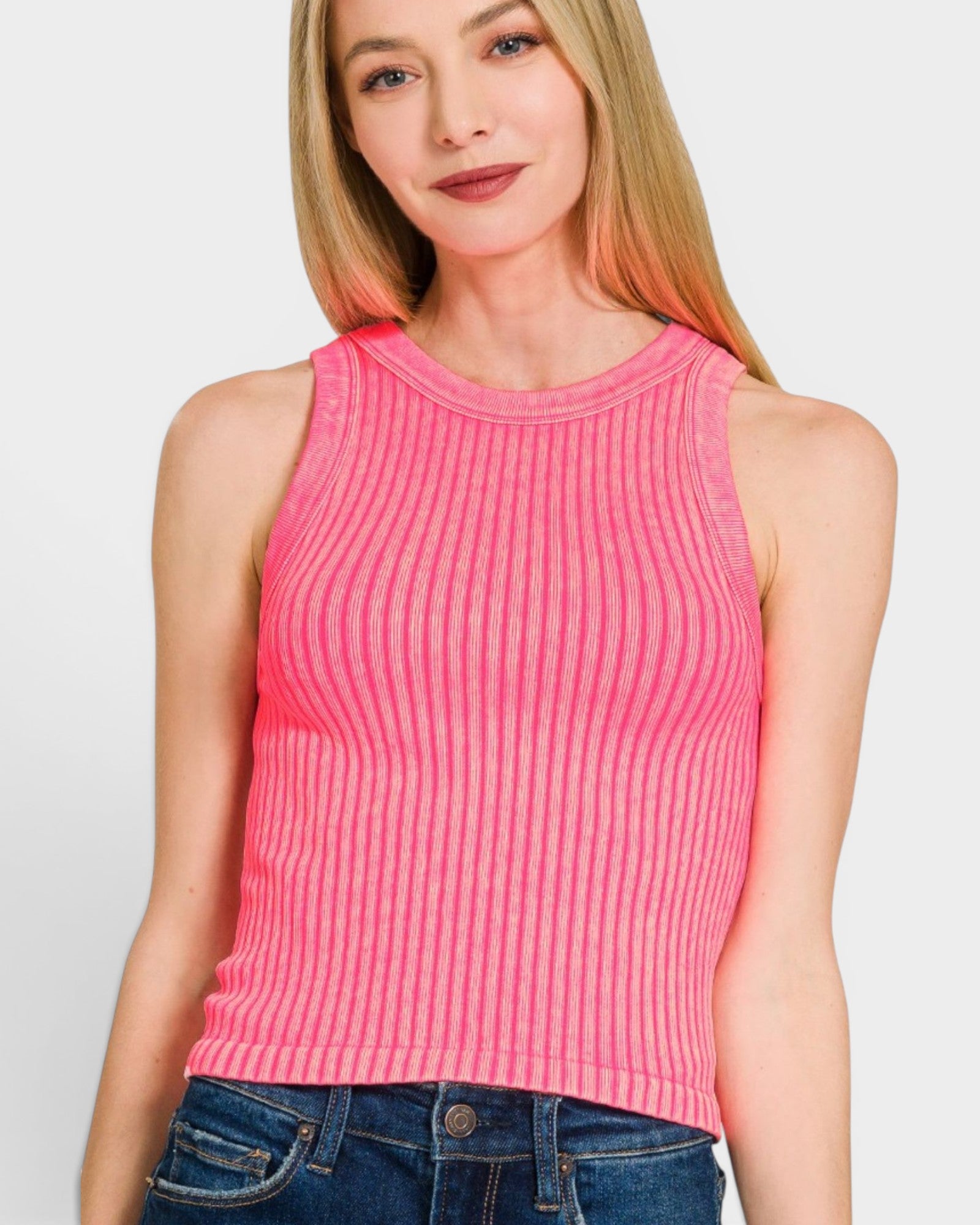 Woman wearing a pink ribbed tank top against a white background
