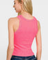 Woman wearing a pink ribbed tank top on a plain background
