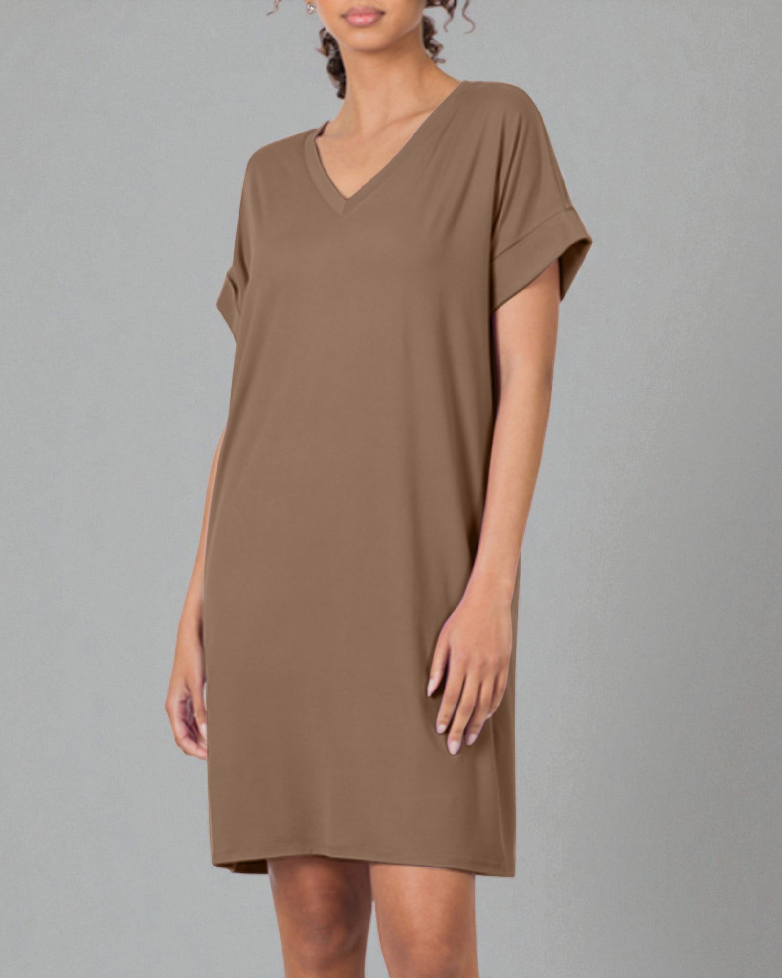 Woman wearing a brown dress against a gray background