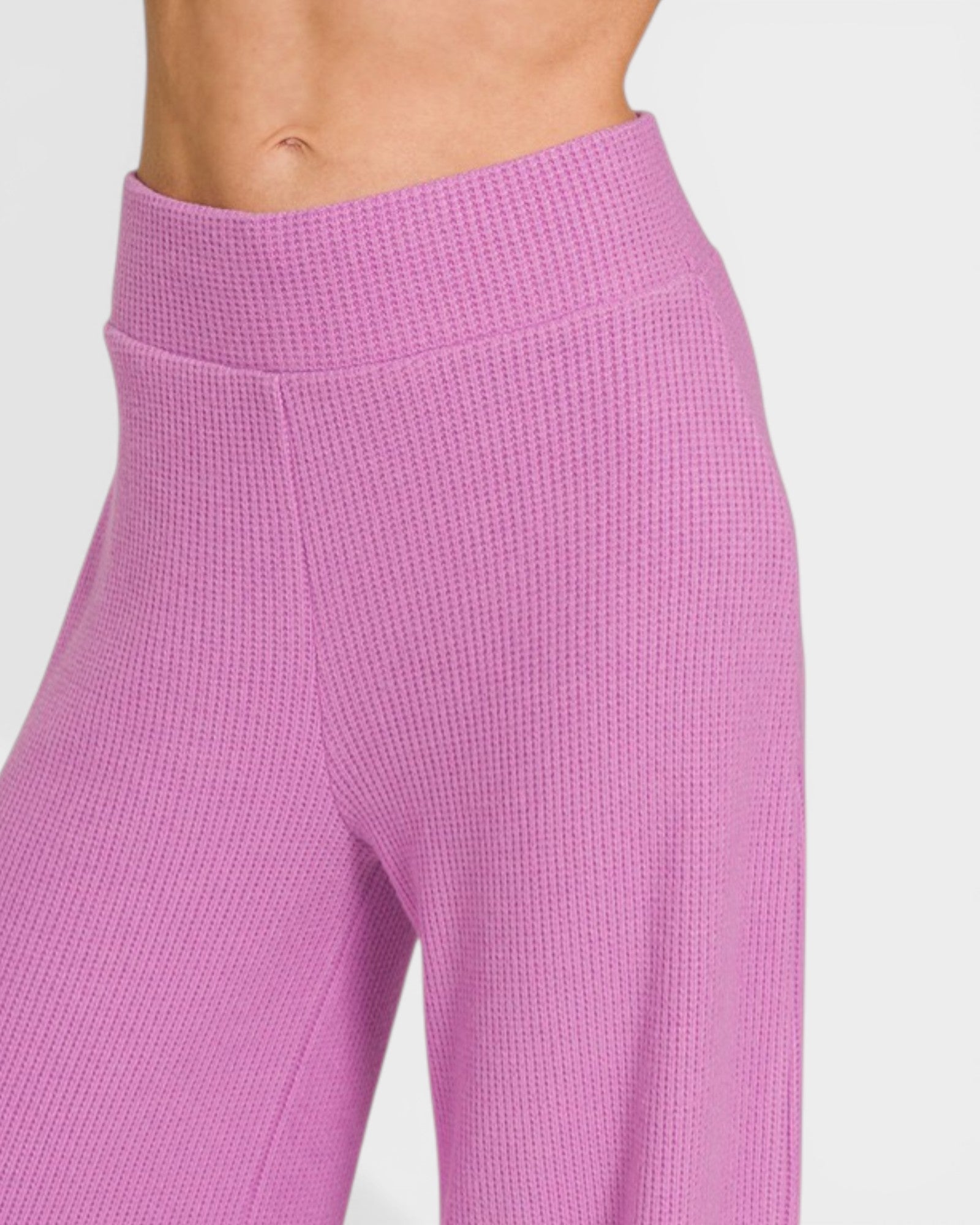 Close-up of purple textured leggings on a plain background