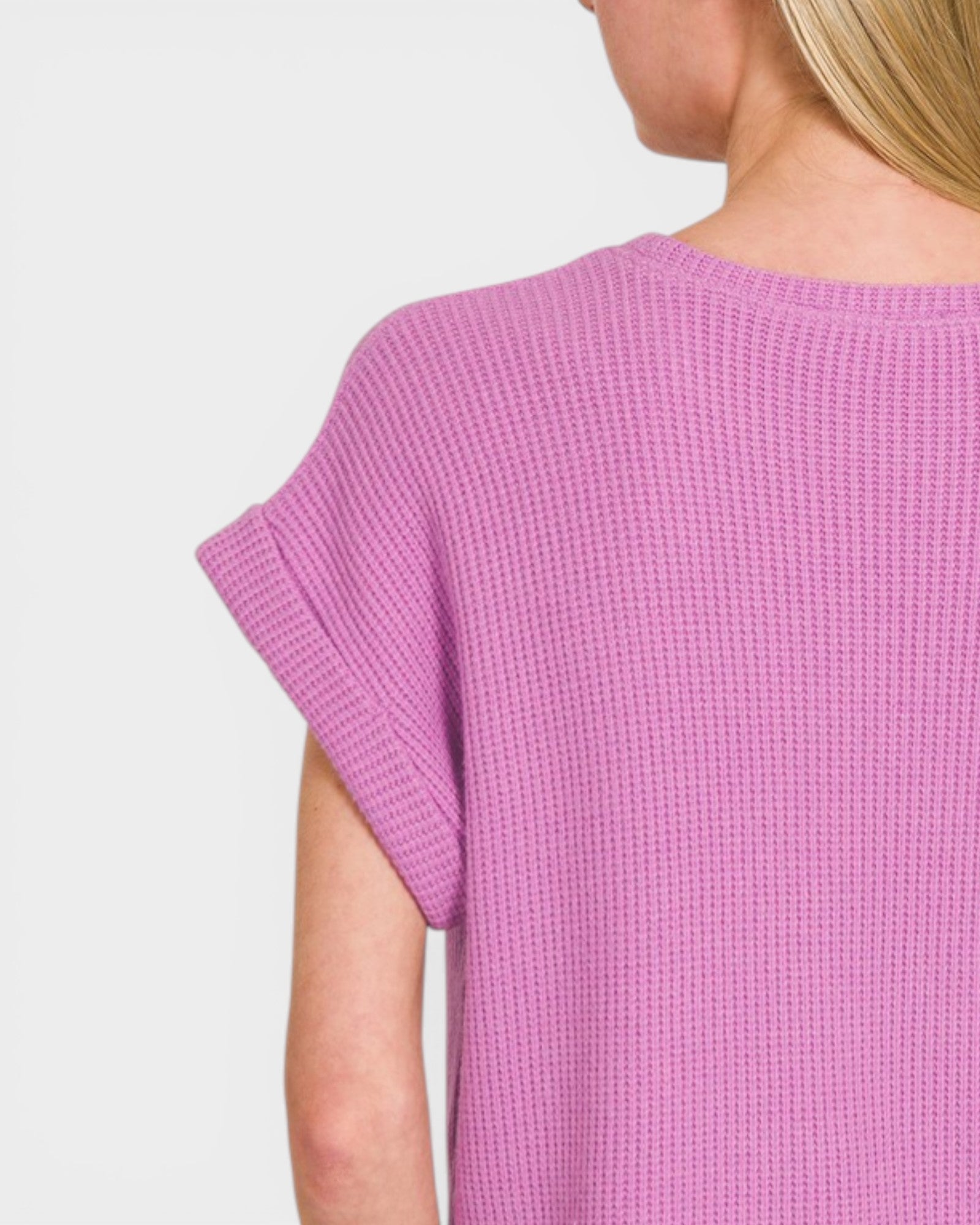 Person wearing a pink textured dress on a plain background