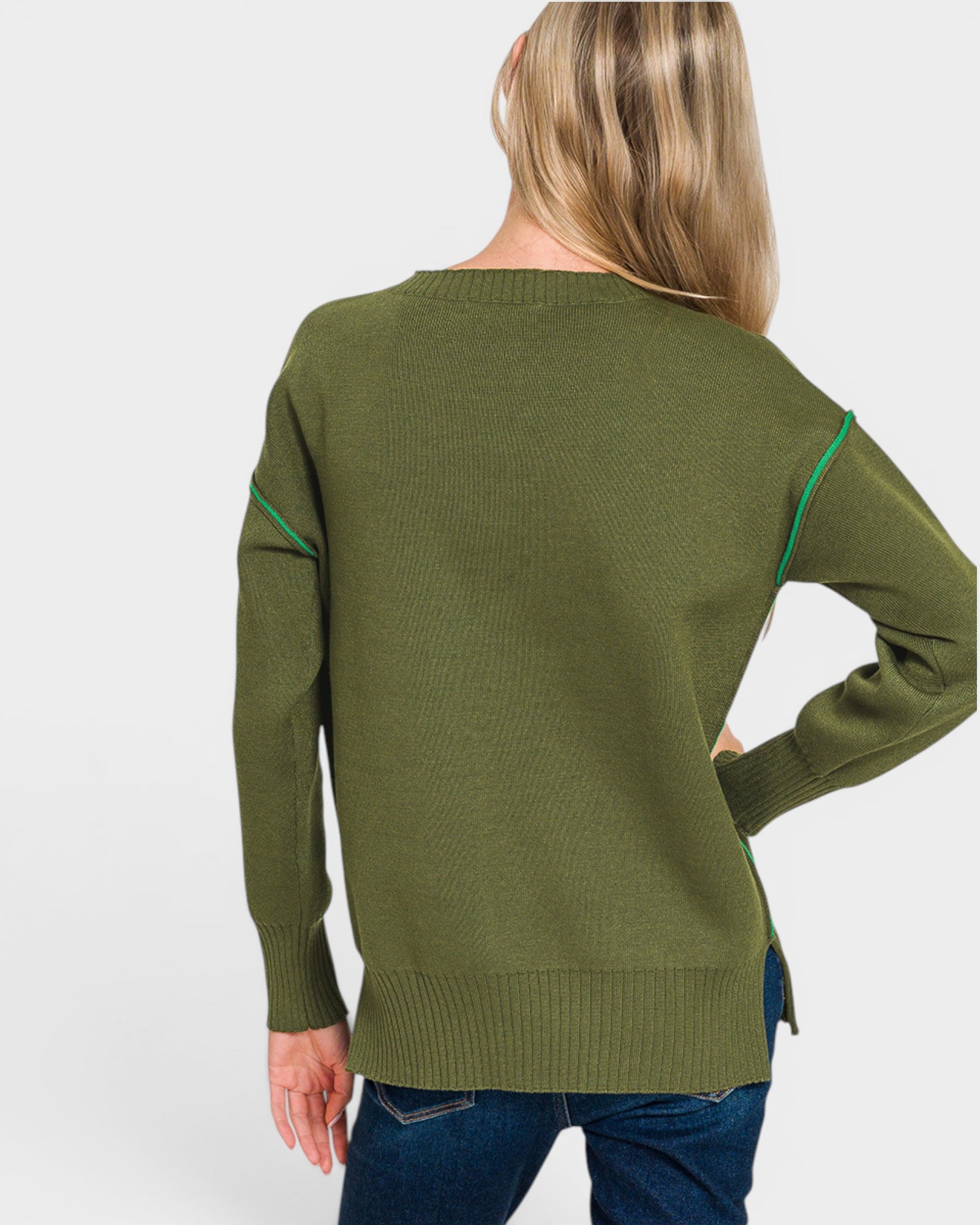 Person wearing a green sweater with green accents on a white background
