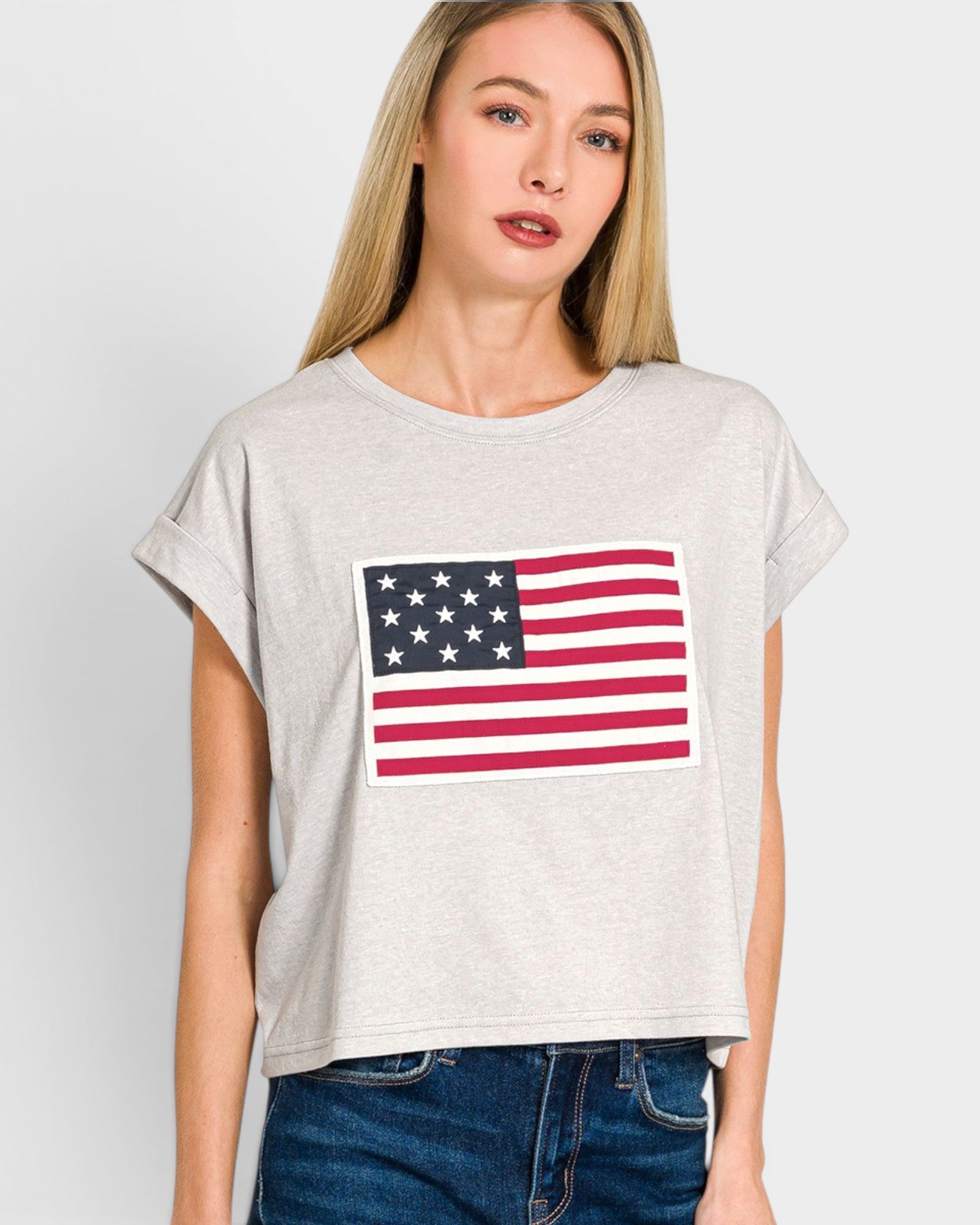 Woman wearing a t-shirt with an American flag design on a plain background