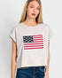 Woman wearing a t-shirt with an American flag design on a plain background