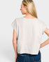 Woman wearing a light gray t-shirt and blue jeans on a white background