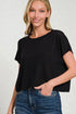 Woman wearing a black top and blue jeans against a white background