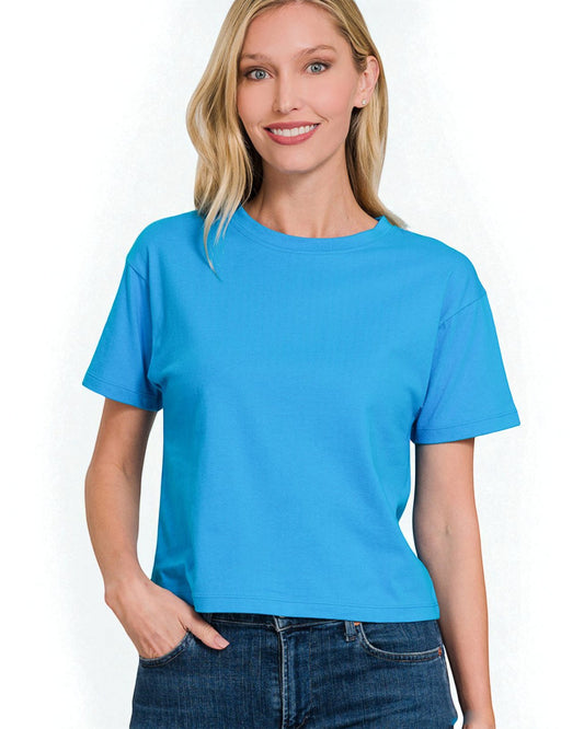 Woman wearing a bright blue t-shirt against a white background