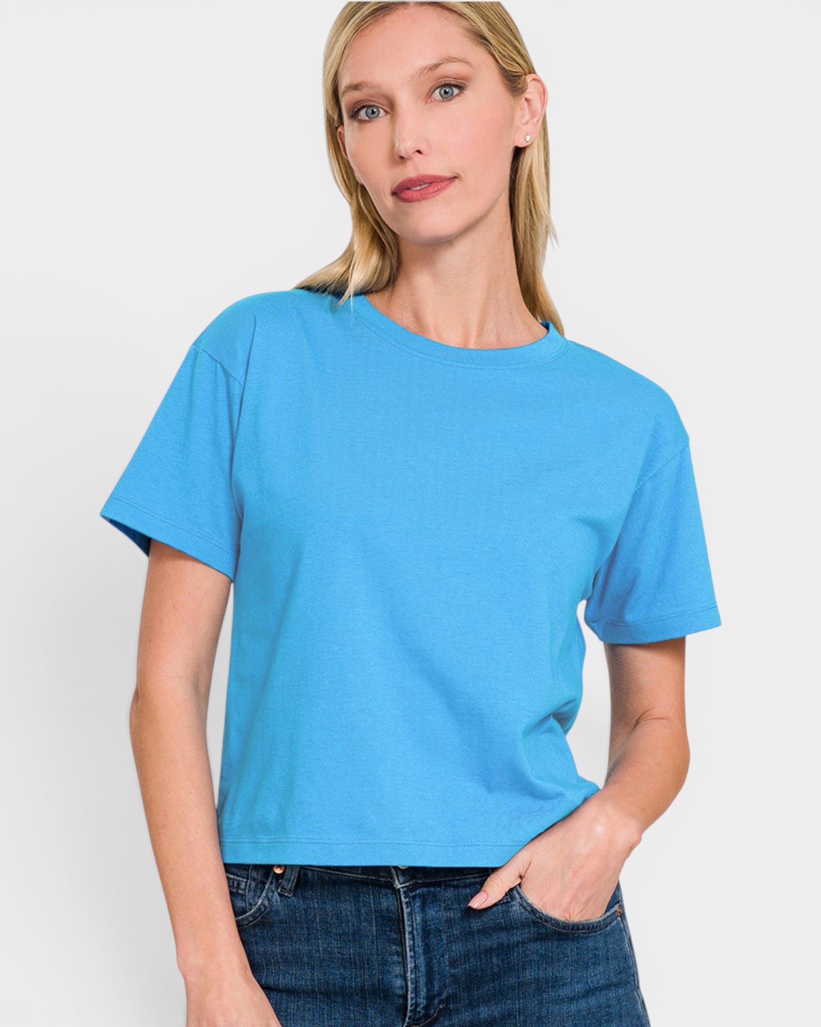 A woman wearing a bright blue short-sleeve t-shirt, against a plain light gray studio background.