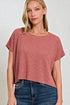 Woman wearing a pink t-shirt and blue jeans against a white background