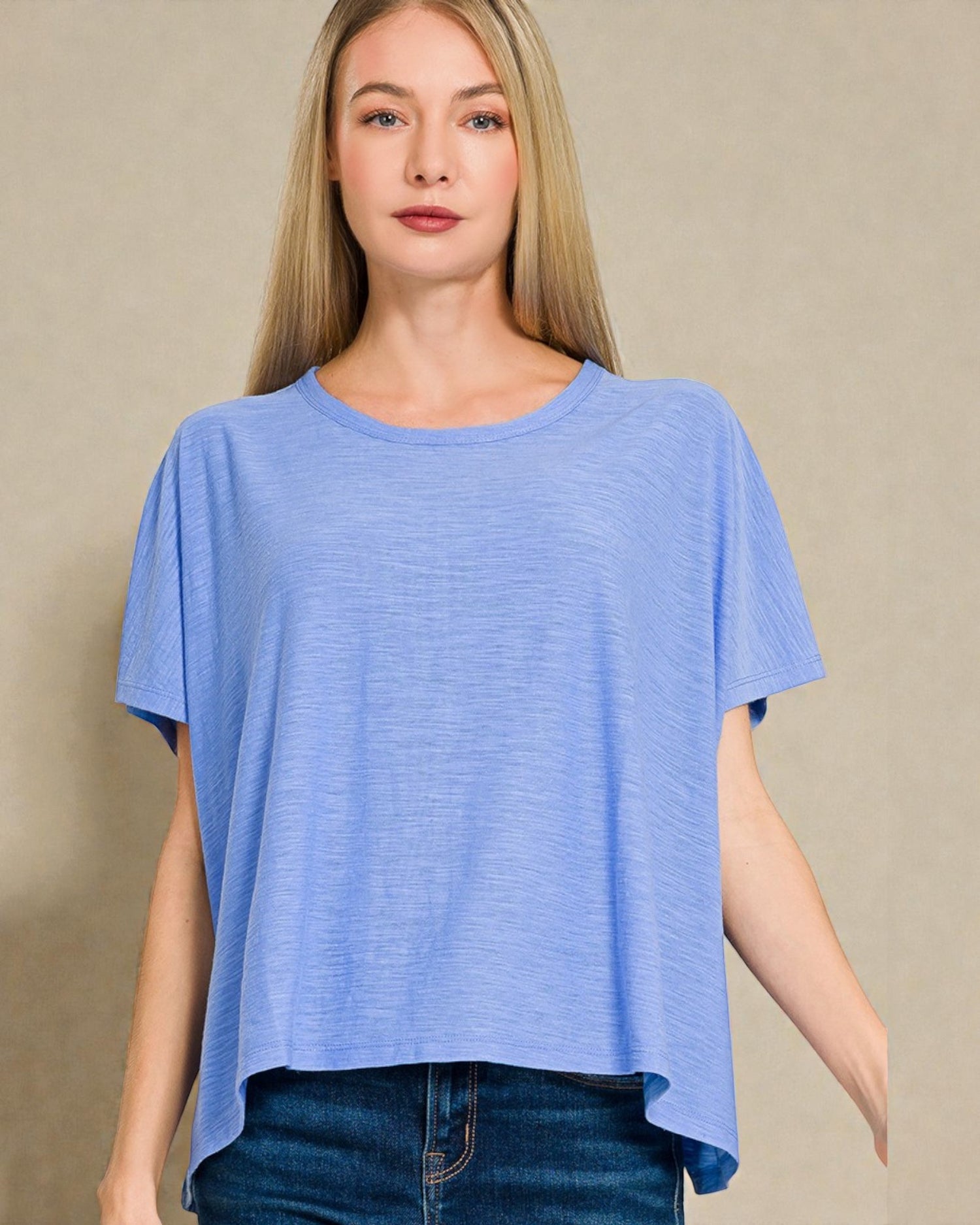 Woman wearing a blue t-shirt against a beige background