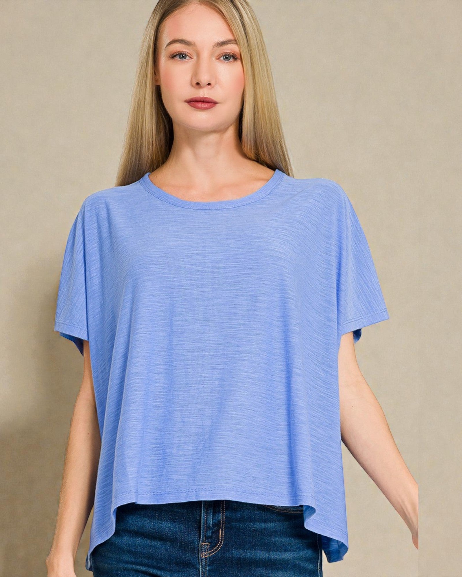 Woman wearing a blue t-shirt against a beige background